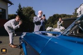 At Villa Bubenzer in Freudenberg, Germany, guests excitedly snap photos of a striking blue vintage American Mustang, the wedding’s showpiece, its classic lines and bold color drawing admiration and joyful attention.